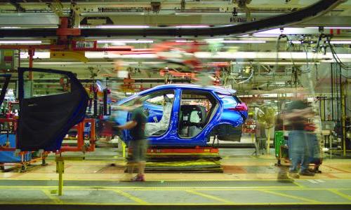 Auto workers construct a car